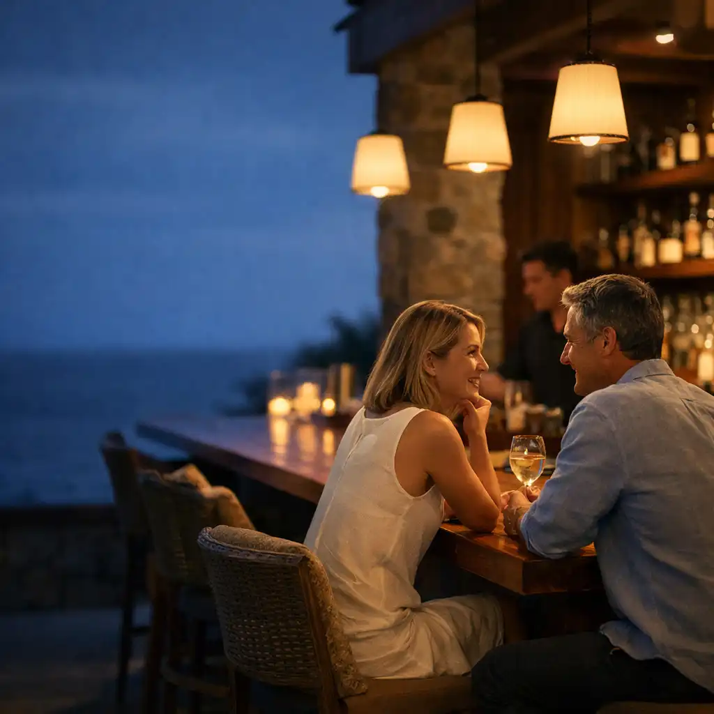 Two adults in relaxed conversation at the evening bar